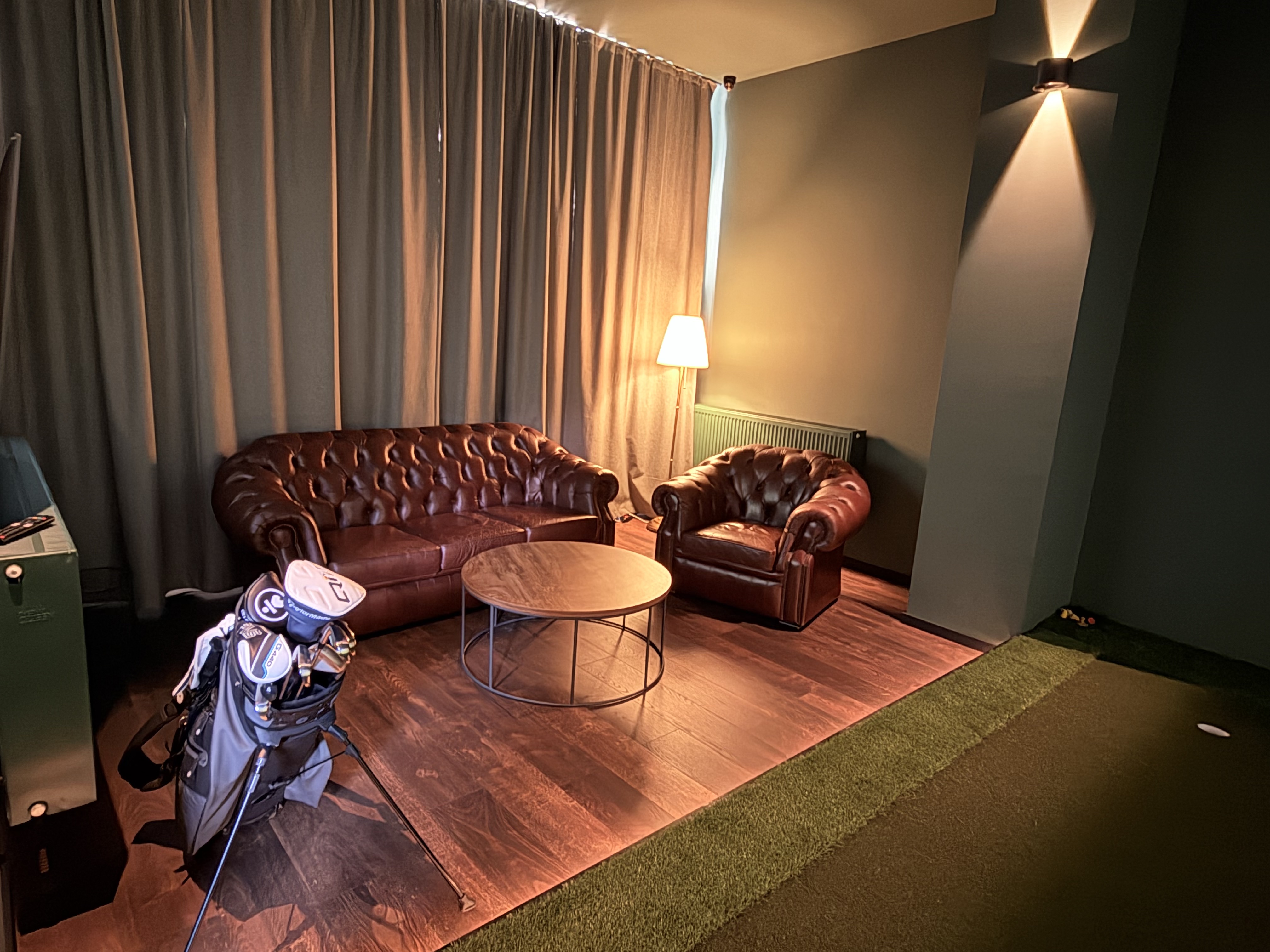 Lounge zona s Chesterfield namještajem i golf torbom u GolfSim.hr